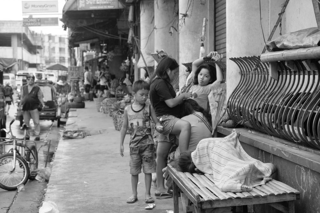 A PUBLIC LIVING ROOM. Children of ambulant vendors play, rest, sleep even on the side of a closed bank along Lopez Jaena Street near Margarita Avenue. |Photo by Lourdes Rae Antenor, text by Julius D. Mariveles