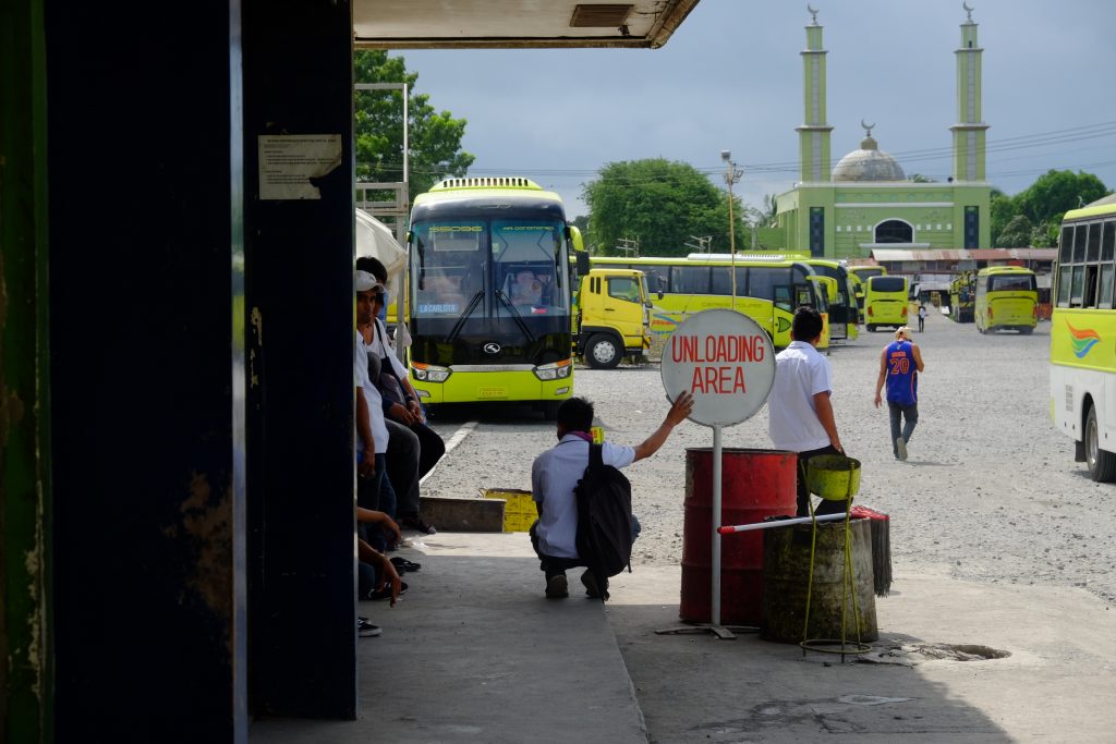 A mosque stands in the background in this photo of buses at the Ceres southern bus terminal in Bacolod City. Since the 1960s when it first began operating, Ceres has expanded its operations to Luzon and Mindanao. Like the deeply divided South, its family members have split into two camps, however, affecting its business operations. | Photo by Jose Aaron C. Abinosa