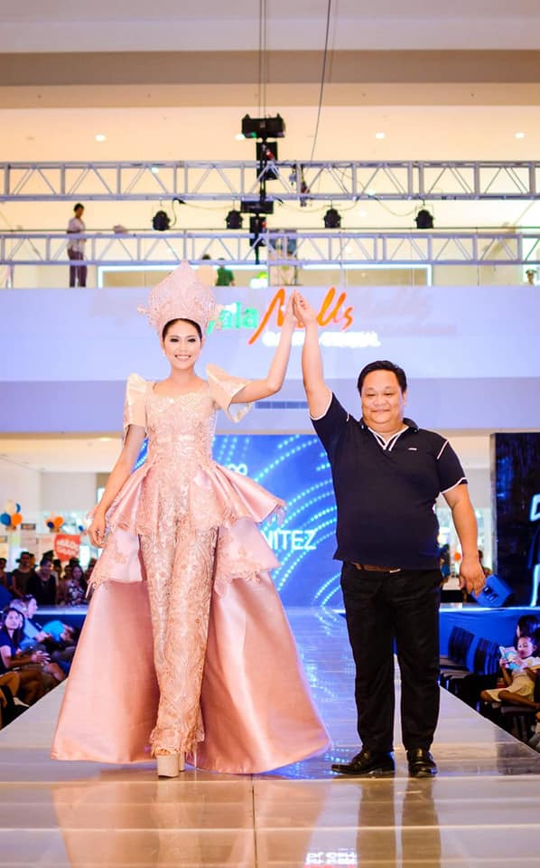 Edwin Benitez with one of his creations.  His gowns define pomp and pageantry. Photo taken with permission from the designer's Facebook page.