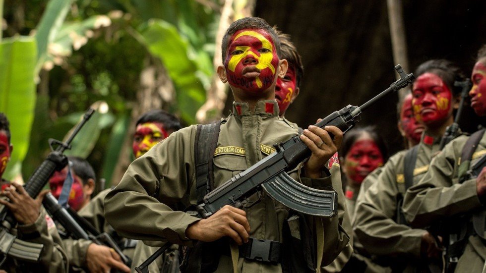 Red fighters of the New People's Army had their faces painted with the CPP flag in an unknown NPA base. | Photo from Philippine Revolutionary Web Central.