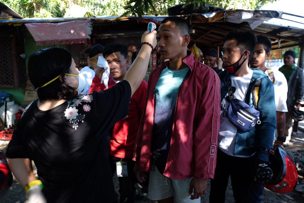 quarantine day one | kwaresma in sugarlandia: of checkpoints and chokepoints, masks, gloves, thermal scanners 2 A government health worker checks the temperature of motorists in passing by the Mansilingan checkpoint to ensure public safety. | Photo by Banjo C. Hinolan