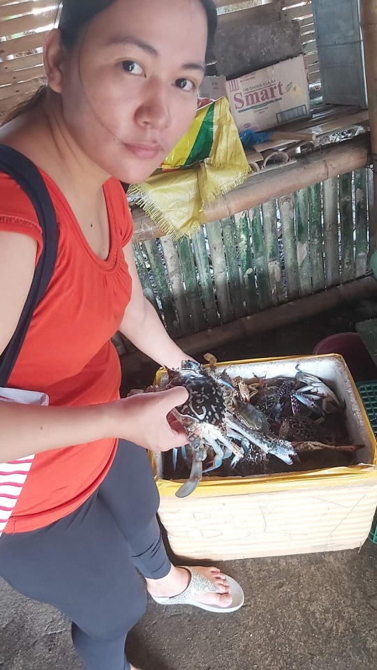 Young mother Pia checking on the quality of the seafood she is selling. | Photo from Pia Yap-Maestrecampos's Facebook page
